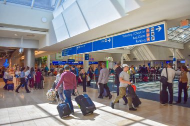 Orlando, Florida 'da. 01 Mart 2019. Orlando Uluslararası Havalimanı 'nda farklı terminaller ve bilet üst görünümü ve check-in mavi işareti yürüyüş insanlar (4).