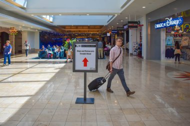 Orlando, Florida 'da. 01 Mart 2019. Orlando Uluslararası Havaalanı 'nda depoya yakın bagajla yürüyen adam (3)