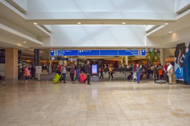 Orlando, Florida 'da. 01 Mart 2019. Orlando Uluslararası Havaalanı 'nda bilet ve check-in mavi tabelası ile farklı terminaller ve üst görünümü ile bagajla yürüyen insanlar 