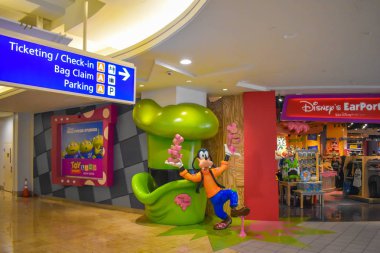 Orlando, Florida 'da. 01 Mart 2019. Bilet ve check-in bilgi işareti ve Goofy yakın Disney Store 'da Orlando Uluslararası Havaalanı .