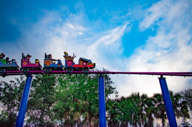 Orlando, Florida. April 7, 2019. People enjoying Cookie Drop rollercoaster family friendly attraction at Seaworld in International Drive area clipart