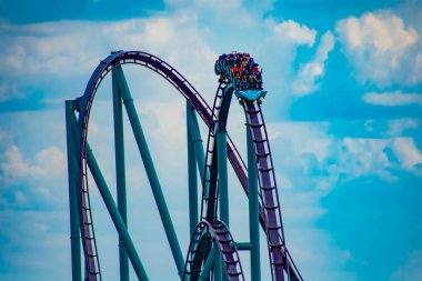Orlando, Florida. 7 Nisan 2019. International Drive alanında Seaworld de lightblue bulutlu gökyüzü arka plan üzerinde müthiş Mako rollercoaster zevk İnsanlar (3)