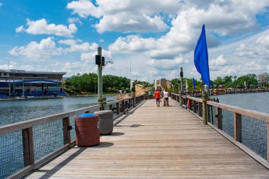 Orlando, Florida. 7 Nisan 2019. International Drive alanında Seaworld lightblue bulutlu gökyüzü arka plan üzerinde ahşap köprü üzerinde yürüyen insanlar 