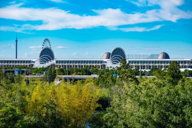 Orlando, Florida. 20 Nisan 2019. Orlando Kongre Merkezi'nin panoramik manzarası ve açık mavi gökyüzü bulutu üzerinde yeşil orman arka planı