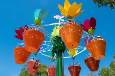 Orlando, Florida. 20 Nisan 2019.International Drive alanında Seaworld'de açık mavi gökyüzü arka planında Abbys Çiçek Kulesi'nde renkli saksıların keyfini çıkaran ebeveynler ve çocuklar (5)