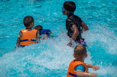 Orlando, Florida. 20 Mayıs 2019. International Drive alanında Aquatica'da havuzda yapay dalgalarla oynayan küçük çocuklar (2)