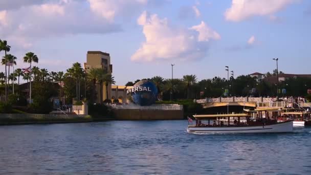 フロリダ州オーランド2019年5月23日ユニバーサルスタジオエリアのシティウォークのユニバーサルスタジオアーチ ワールドスフィア ヤシの木 タクシーボートのパノラマビュー — ストック動画