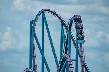 Orlando, Florida. 30 Haziran 2019. Seaworld lightblue gökyüzü bulutlu arka plan üzerinde eğlenceli Mako roller coaster olan insanların Müthiş görünümü.