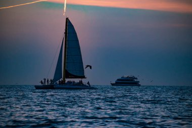 Clearwater Plajı, Florida. 24 Haziran 2019. Gulf Coast Plajlar 1 renkli günbatımı arka plan üzerinde yelkenli ve lüks yate zevk İnsanlar