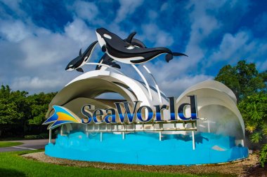 Orlando, Florida. 17 Haziran 2019. Seaworld işareti ve açık mavi bulutlu arka plan 1 üzerinde balina figürleri