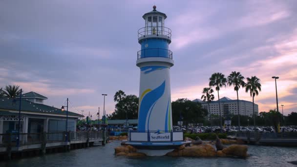 フロリダ州オーランド2019年7月12日日没の背景にシーワールド灯台とアシカの像のパノラマビュー — ストック動画