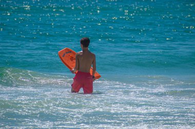 Daytona Beach Florida. 07 Temmuz 2019 Main Street Pier bölgesinde sörf tahtası zevk dalgaları ile çocuk 3.