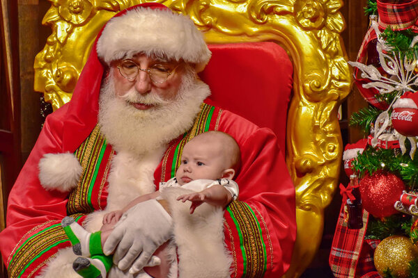 Орландо, Флорида. 22 ноября 2018 года. Санта-Клаус с ребенком на Рождество в Seaworld
 ..