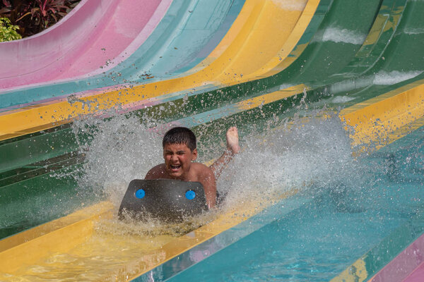 Orlando, Florida. October 24, 2019. Boy enjoying amazing splashing in Tamauta Racer attraction at Aquatica