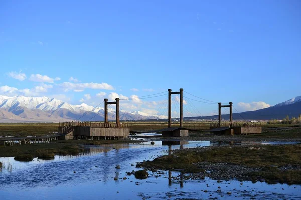 Gramados dourados bonitos com rio em Tashkurgan com montanhas cobertas de neve, Xinjiang, China — Fotografia de Stock