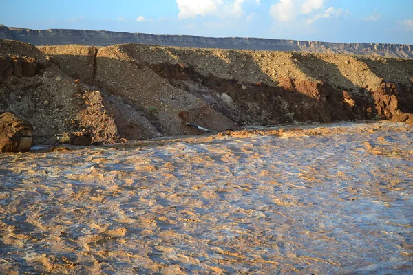 Huge Flash flood in Mitzpe Ramon Crater, Negev desert in South Israel, streams floods of water in the desert wilderness