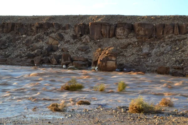 Huge Flash flood in Mitzpe Ramon Crater, Negev desert in South Israel, streams floods of water in the desert wilderness