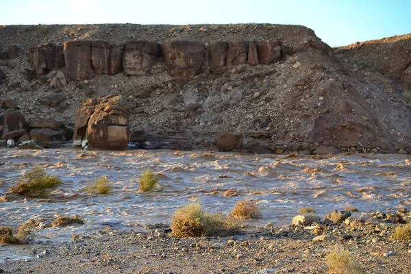 Huge Flash flood in Mitzpe Ramon Crater, Negev desert in South Israel, streams floods of water in the desert wilderness