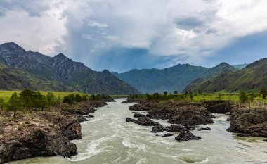 Dramatik fırtına bulutları dağların üst üzerinden ulaşır Katun nehrin Altay