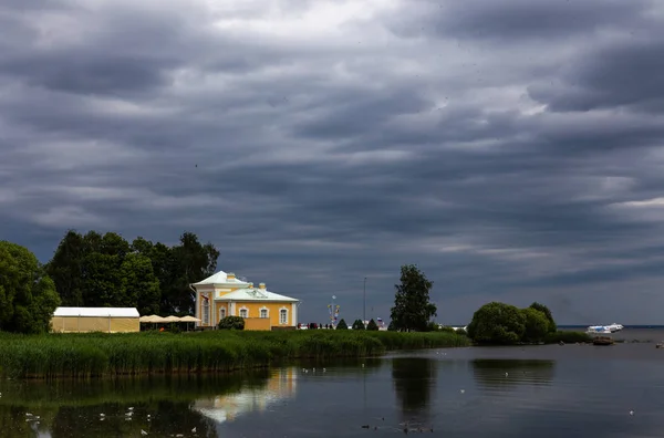 Altes Herrenhaus an der Küste des Golfs von Finnland unter dramatischen Gewitterwolken. Peterhof. Russland. — Stockfoto