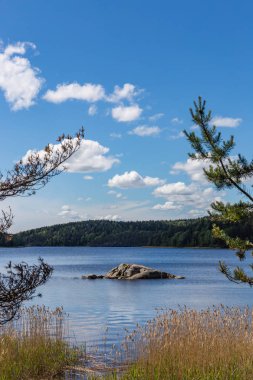 Taş şaman bulutlar, Karelya ile mavi gökyüzü altında doğal görünümü üzerinde göl Tulmozero. Rusya