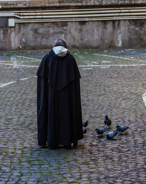 Monge beneditino alimentando pombos na rua, Roma, Itália — Fotografia de Stock