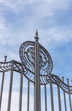 Novosibirsk, Rusya'da metal bir kapıdan beyaz bulutlarla mavi gökyüzünün görünümü