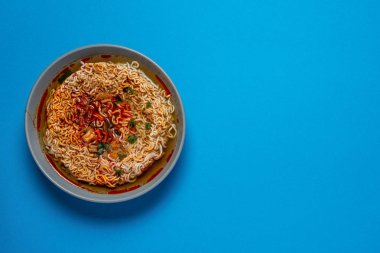 kopya alanı için bir yer ile mavi bir arka plan üzerinde çubuklar ile anlık erişte çorbası pişirilir