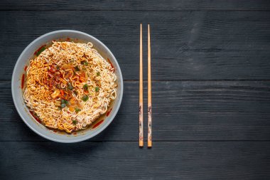 kopya alanı için bir yer siyah bir ahşap zemin üzerinde çubuklar ile anlık erişte çorbası pişirilir