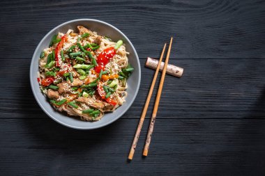 Tay şehriye wok kopya alanı için bir yer siyah bir ahşap zemin üzerine çubuk ile