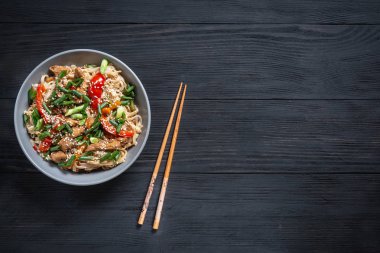 Tay şehriye wok kopya alanı için bir yer siyah bir ahşap zemin üzerine çubuk ile