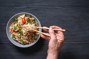 man çubuk siyah ahşap zemin ile Tay erişte wokes yemek