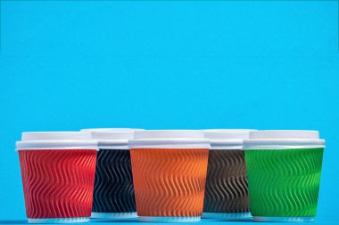 tek kişi kullanımlı mavi bir arka plan üzerinde renkli karton bardak