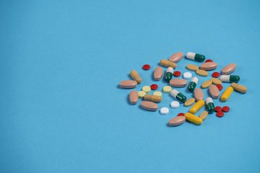 çok renkli hapları kopya alanı için bir yer ile mavi bir arka plan üzerinde dağınık