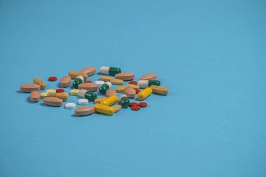 çok renkli hapları kopya alanı için bir yer ile mavi bir arka plan üzerinde dağınık