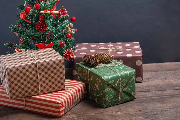 在黑色背景下的圣诞树下的各种和明亮的礼物 — 图库照片