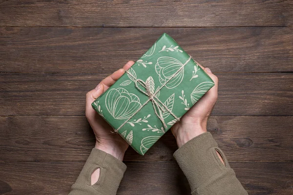 man presents a New Year\'s gift in festive packaging