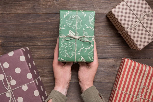 man presents a New Year's gift in festive packaging