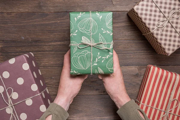 man presents a New Year\'s gift in festive packaging