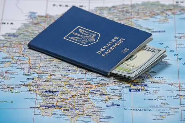 マップ背景にドルでウクライナのパスポート 収益または休暇の移住キット — ストック写真