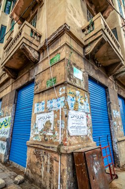 Bulutlu bir günde eski reklam ile parlak ve mavi kapı ile eski bir evin bir köşesinde tür İskenderiye, Mısır, 11.16.2018 sular altında