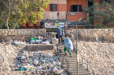 18/11/2018 Kahire, Mısır, gençlerin toplayın ve çöp Afrika başkenti sokaklarında büyük torbalarda güneşli bir günde sıralayın.