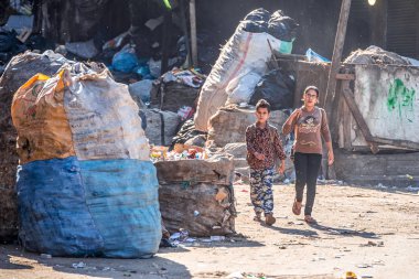11/18/2018 Kahire, Mısır, çocuklar arasında bir sürü çöp ve kabul edilemez pis bir çöp şehrin sokakta güneşli bir günde okula