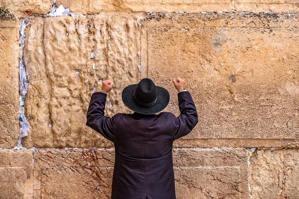 Yahudi dua büyük bir siyah şapka ellerini yokuş yukarı yükselterek ağlayan duvarın yanında mümin.