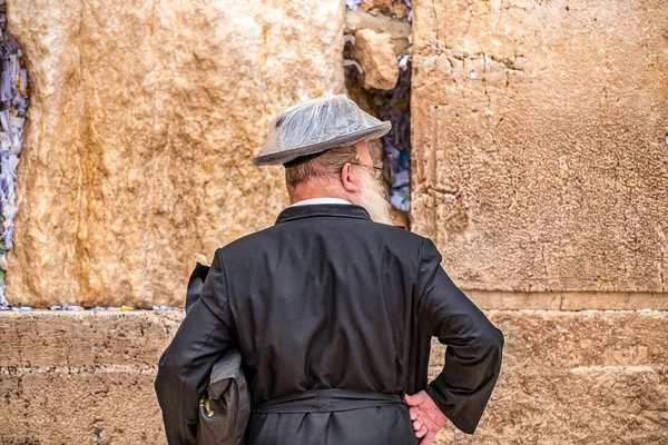 雨の下でレインカバーの大きな黒の帽子で泣いての壁付近に祈っているユダヤ人を信じること — ストック写真
