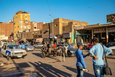 13/11/2018 Aswan, Mısır, kalabalık sokakları ve kaotik trafik ve çok sayıda tabela ve reklam batımında ile Güney Mısır'daki eski ve kötü bir şehrin sokaklarında