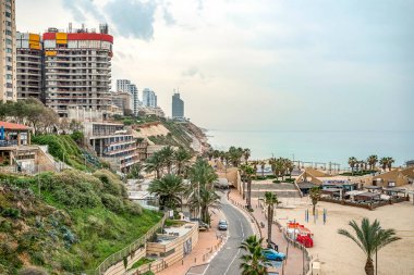11/24/2018 Netanya, İsrail, palmiye ağaçları ve yüksek binalar ile bulutlu rüzgarlı bir gün resort şehirde kıyısında