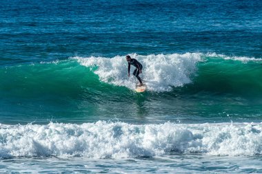 12/18/2018 Netanya, İsrail, sörfçü dalgası üzerinde sürmek ve günbatımında bir dalga üzerinde hile yapmak