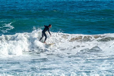 12/18/2018 Netanya, İsrail, sörfçü dalgası üzerinde sürmek ve günbatımında bir dalga üzerinde hile yapmak