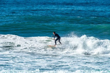 12/18/2018 Netanya, İsrail, sörfçü dalgası üzerinde sürmek ve günbatımında bir dalga üzerinde hile yapmak